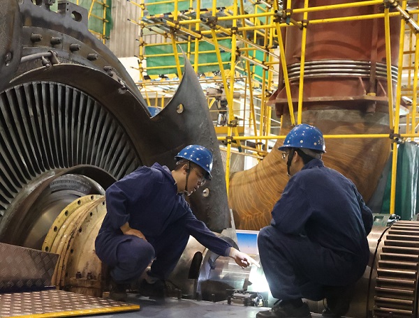 檢修部汽機(jī)車(chē)間本體班技術(shù)人員在研究螺栓切割方案。.jpg